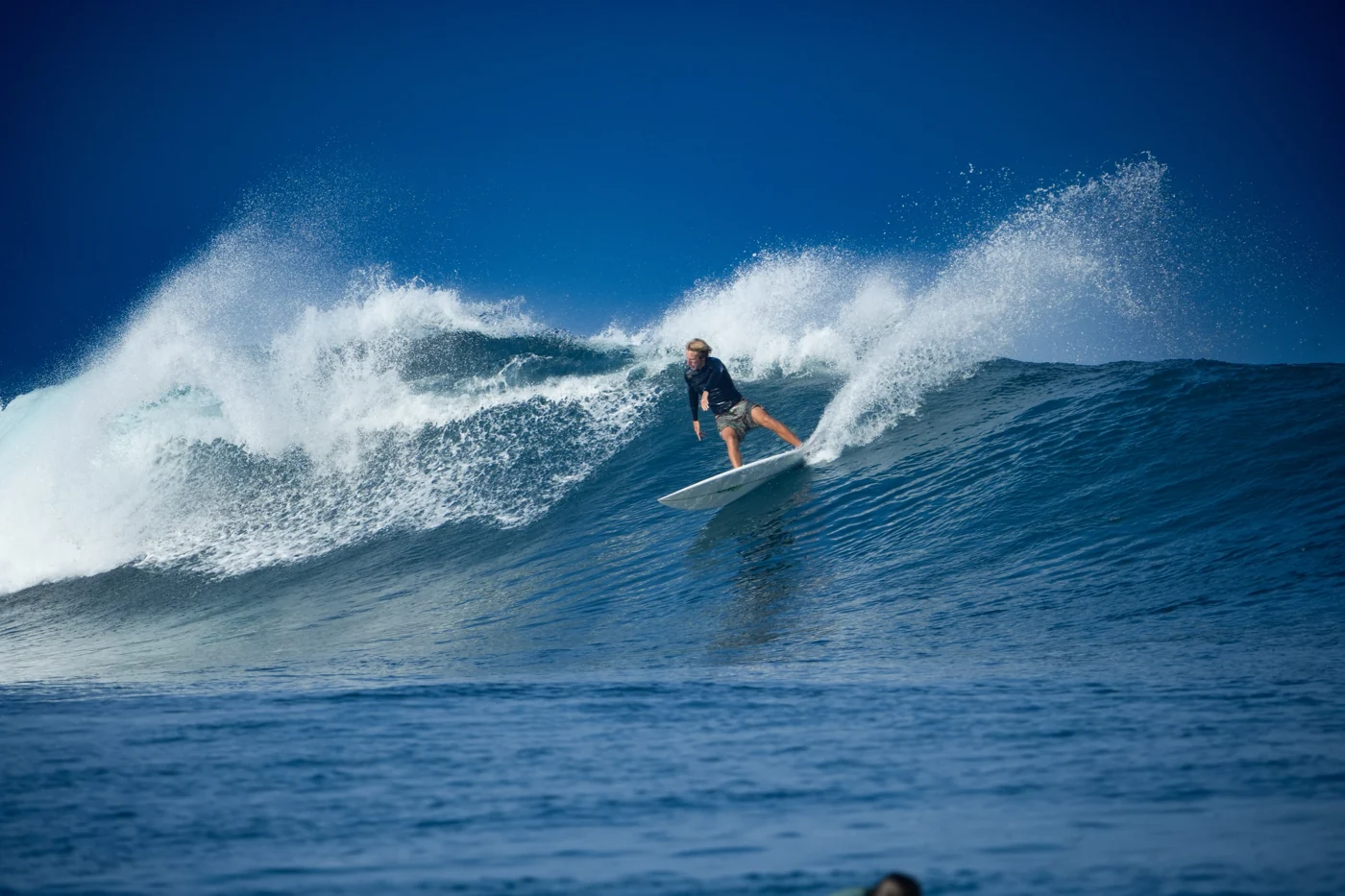 A surfer making a powerful turn and throwing spray